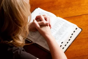 Uma mulher lendo a bíblia. Simbolizando o início de um dia com um Devocional