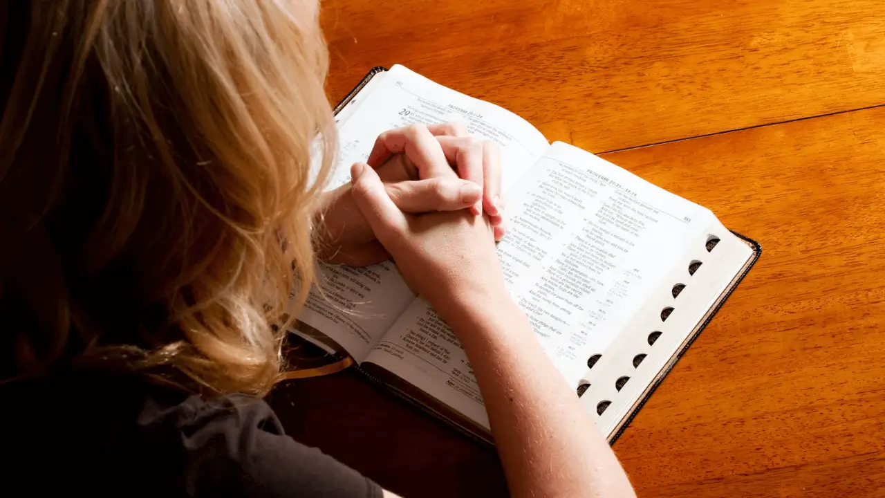 Uma mulher lendo a bíblia. Simbolizando o início de um dia com um Devocional