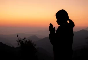 Imagem de uma pessoa meditando olhando o pôr do sol. Remetendo a um Devocional