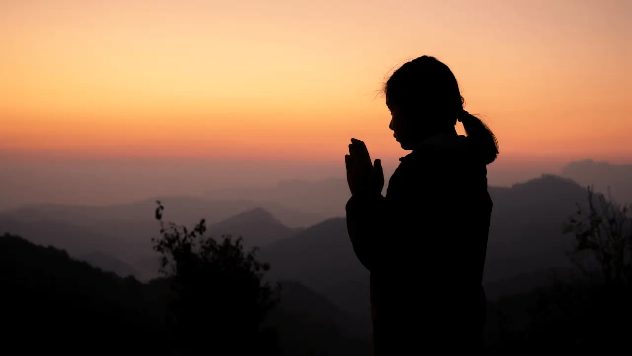 Imagem de uma pessoa meditando olhando o pôr do sol. Remetendo a um Devocional