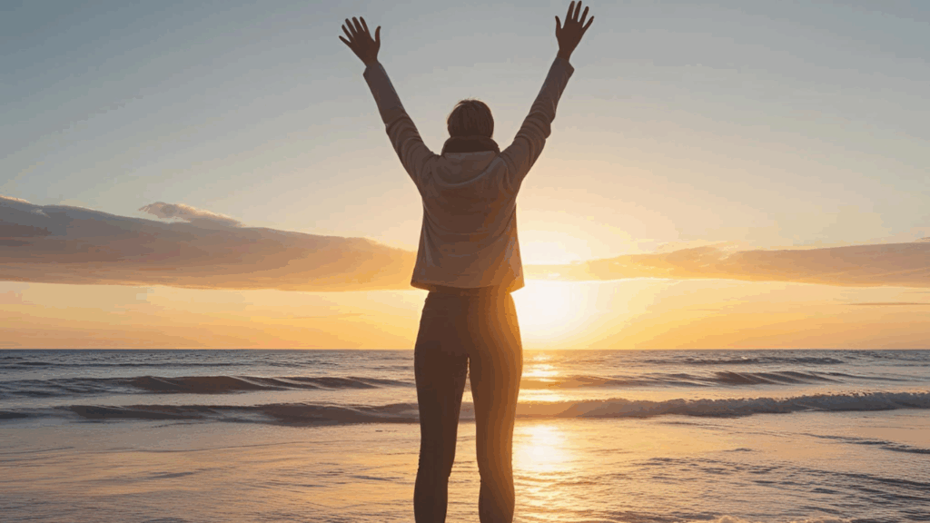 Imagem do devocional – Mulher em pé com braços levantados ao céu durante o nascer do sol, expressando louvor e alegria.