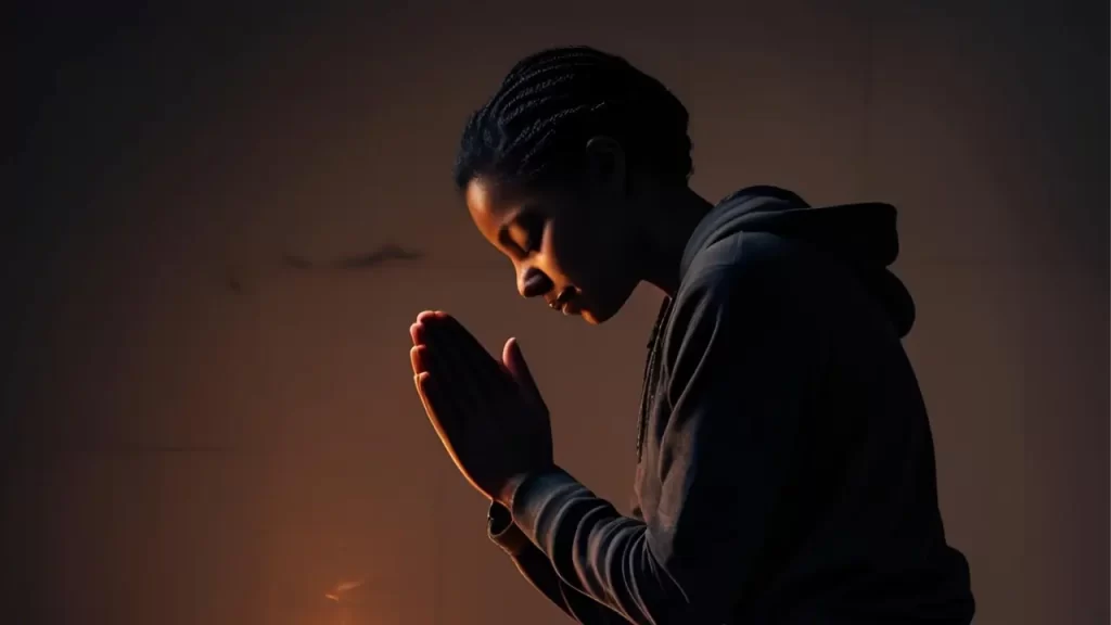 Pessoa orando em meio à escuridão, simbolizando confiança em Deus mesmo em tempos difíceis.