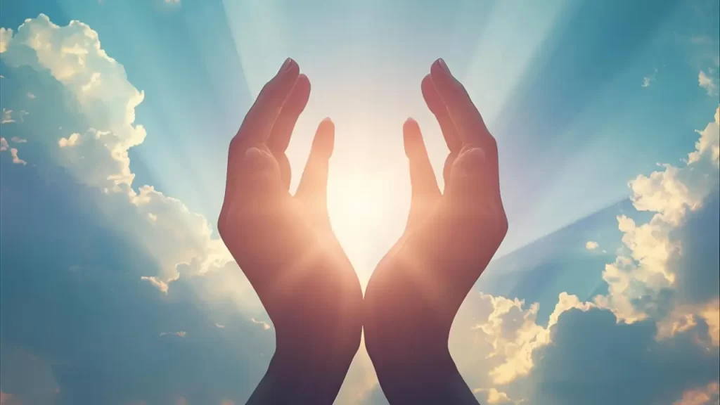 Céu com raios de sol com mãos abertas em oração.