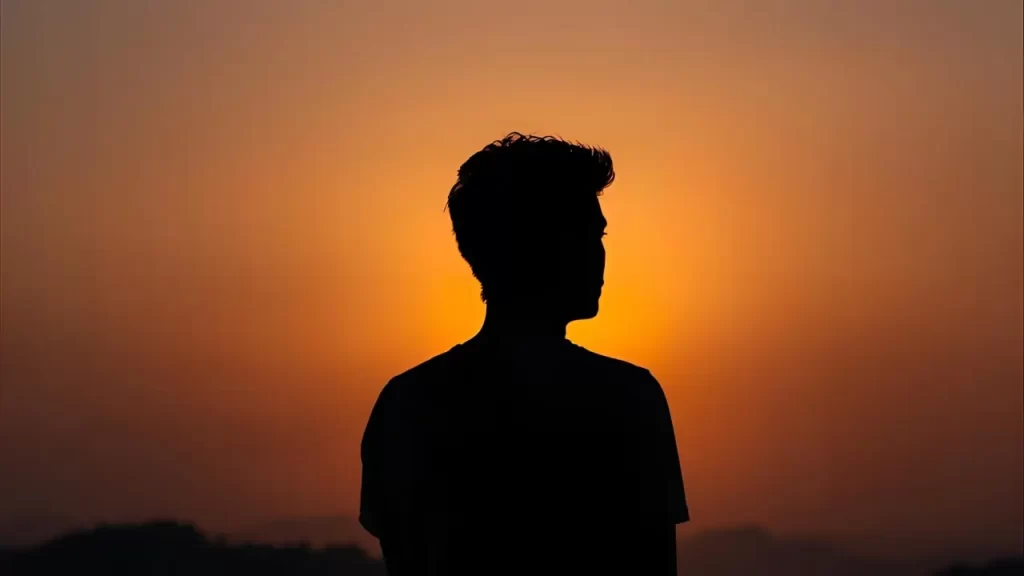 Silhueta de alguém olhando o horizonte durante o amanhecer, simbolizando fé e esperança no futuro.