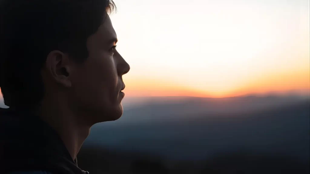 Pessoa olhando para o horizonte com semblante pensativo.