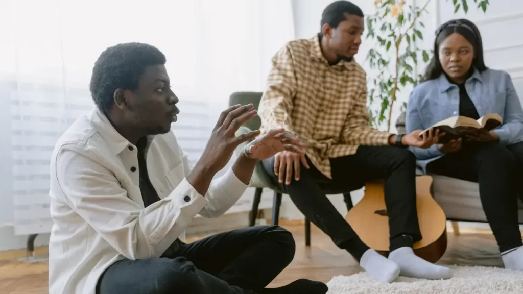 Grupo de pessoas escrevendo versículos e estudando a Bíblia. 