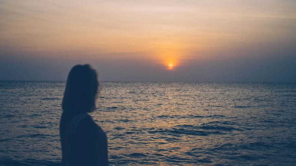 Pessoa contemplativa olhando para o horizonte, simbolizando reflexão.