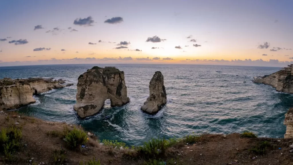Uma  rocha firme à beira-mar, resistindo às ondas. simbolizando Cristo como base inabalável da vida.