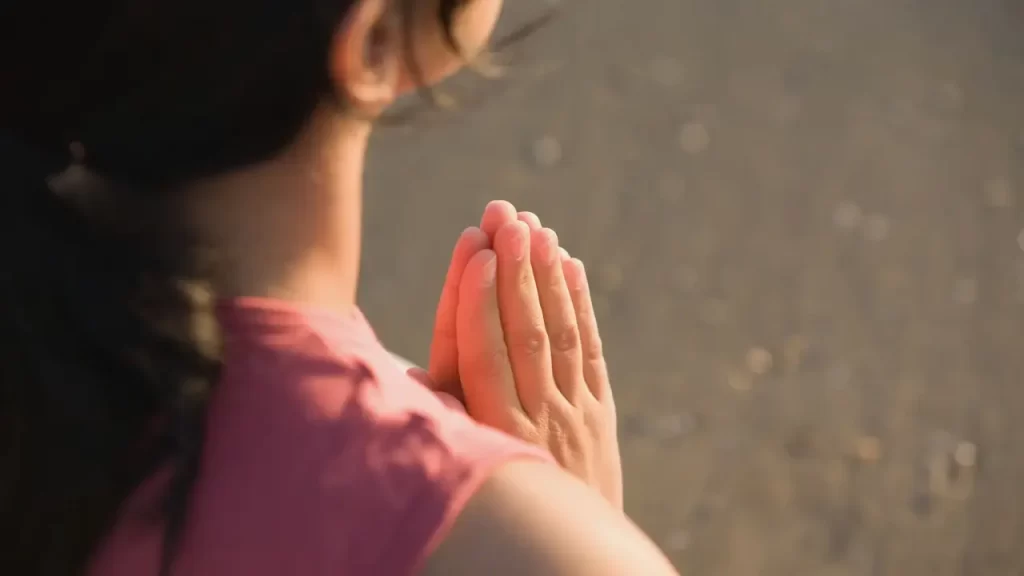 Pessoa olhando para o horizonte ou mãos levantadas em oração.