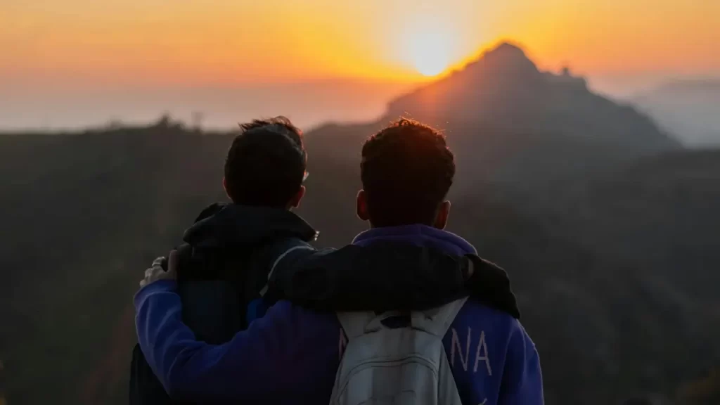 Duas pessoas contemplando o pôr do sol. 