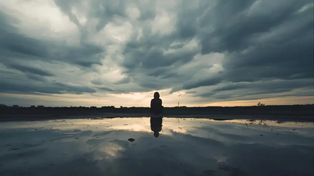 Foto simbólica que represente cansaço emocional, com alguém  refletindo,  com paisagem nublada. 