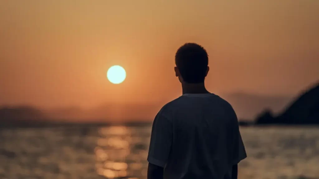 Uma imagem inspiradora de alguém olhando para o alto, ao amanhecer.