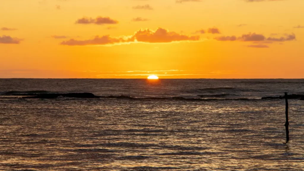 Uma imagem com atmosfera de renovo: nascer do sol, luz forte atravessando nuvens, ao amanhecer.