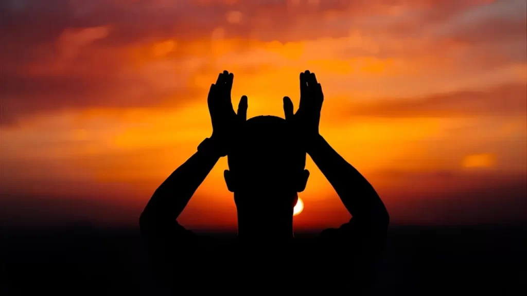 uma pessoa orando, mãos erguidas. 