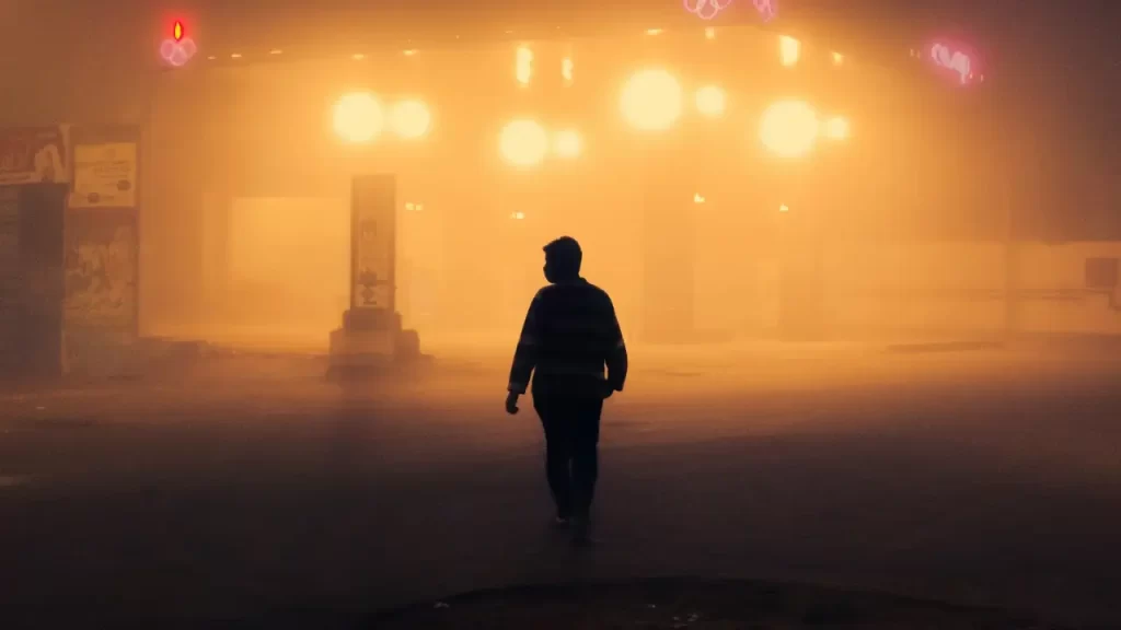 Pessoa caminhando em direção à luz ao amanhecer. 