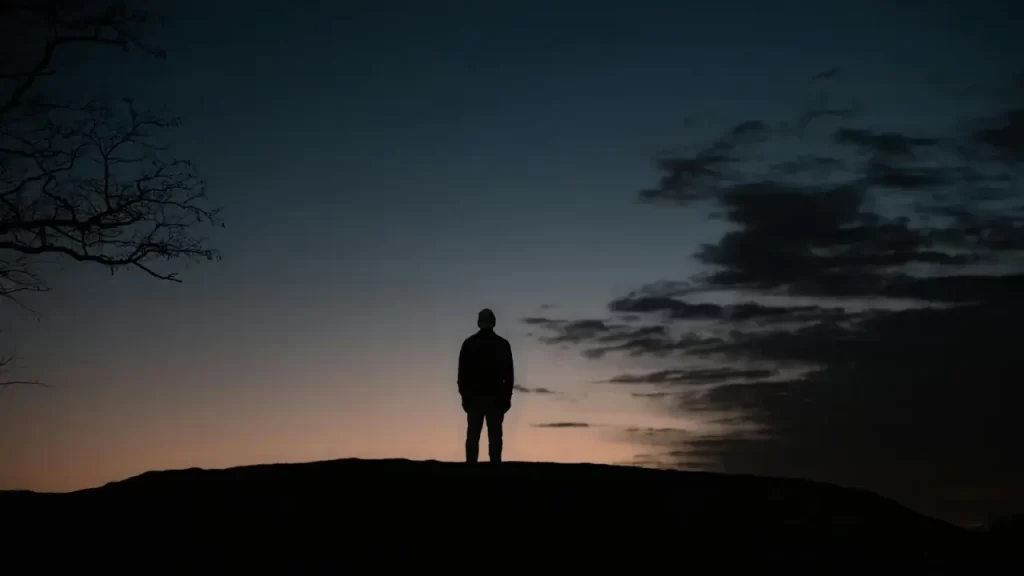 Pessoa orando ao amanhecer. 