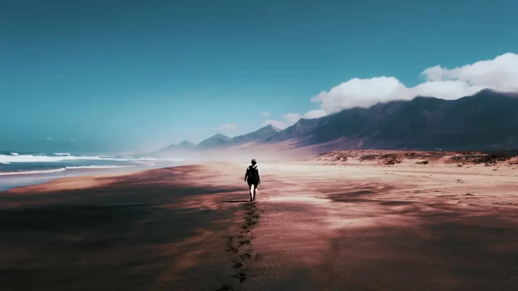 Pessoa olhando para o horizonte na beira da praia. 