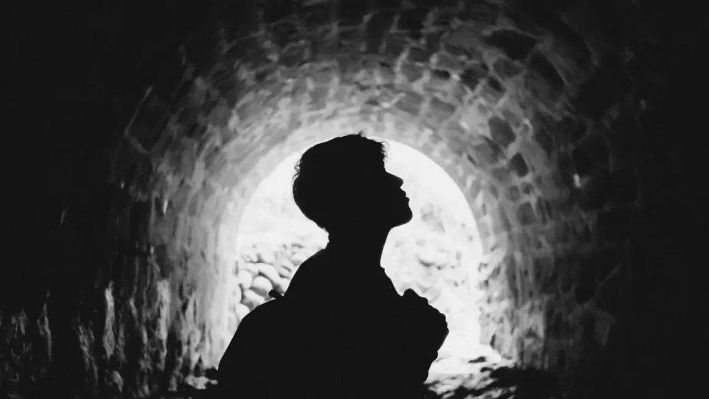 Silhueta de alguém com expressão de ansiedade ou reflexão.