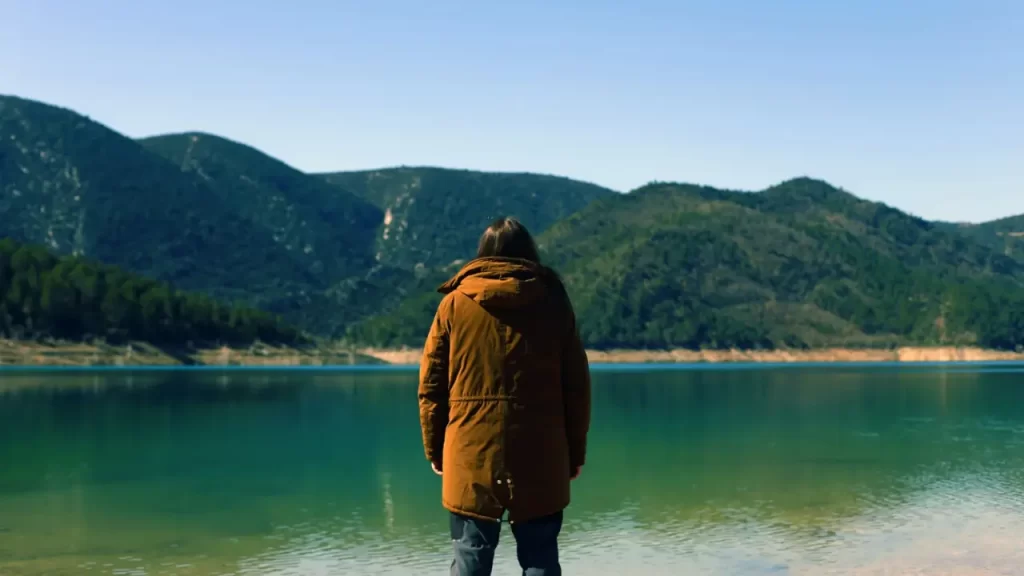 Pessoa orando olhando para o horizonte. Representa a ideia de prosseguir para o alvo, ensinada em Filipenses 3:14.