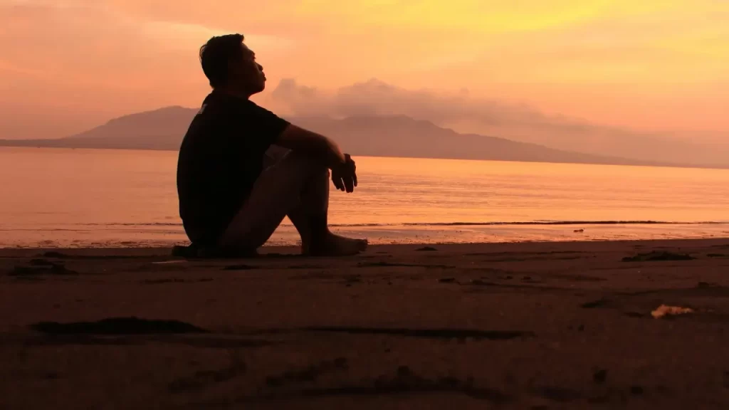 Silhueta em oração ao pôr do sol. 